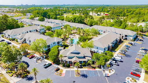 A parking lot with cars and a building in the background.