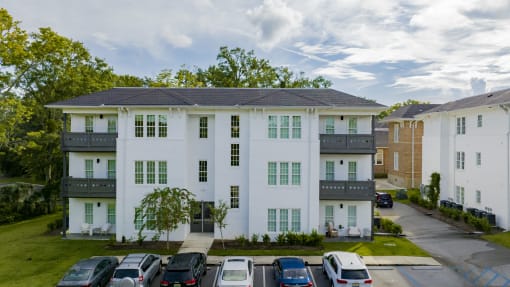 a white apartment building with cars parked in front of it at The Mobile Lofts, Mobile, 36604