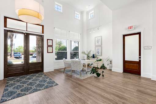A room with a table and chairs and a rug on the floor.
