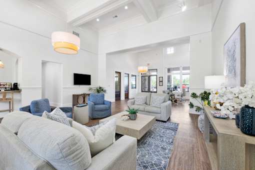 A spacious living room with a grey sofa and a white couch.