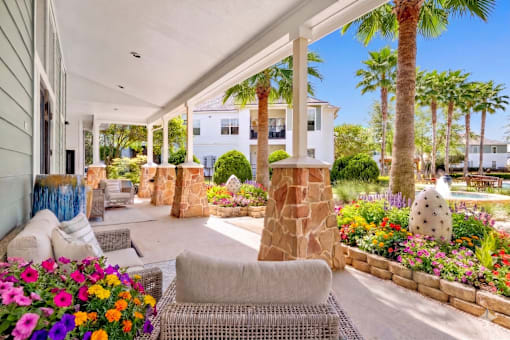 A patio with a stone pillar and a wicker chair.