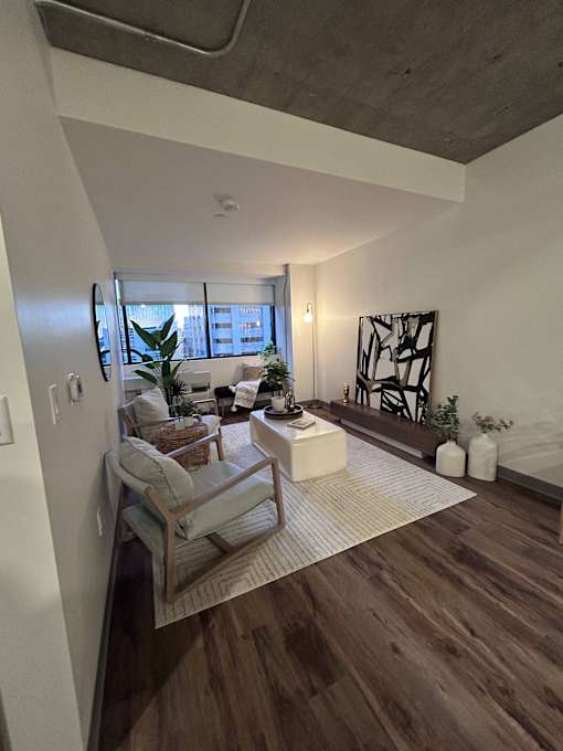 A living room with a wooden floor and a white wall.