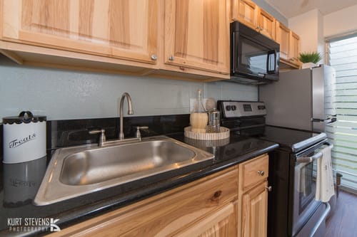 Kewalo Apartments kitchen area with appliances, counters, and cabinets