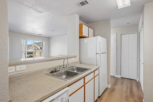Pines at Castle Rock 2728 kitchen with white appliances and wooden cabinets.