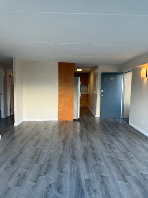 A room with a grey floor and a blue door.