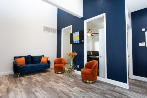 a living room with blue walls and a couch and chairs