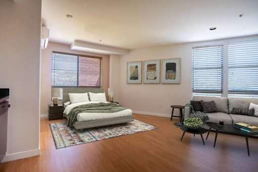A bedroom with a bed, a couch, and a coffee table.