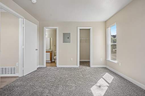 A room with a carpeted floor and a window on the right side.