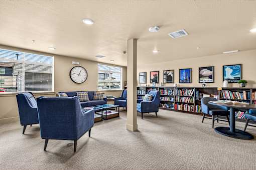 A living room with blue chairs and a carpet.