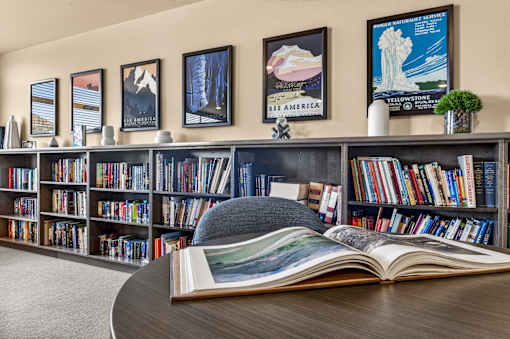 A bookshelf filled with books and a book open in front of it.
