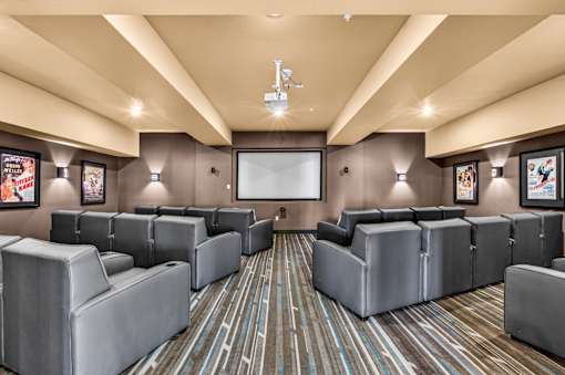 A room with grey couches and a striped carpet.