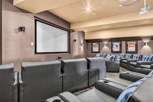 A home theater with a row of seats and a large screen.