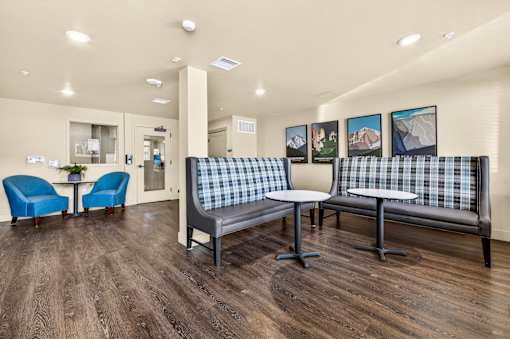 A waiting room with a couch, chairs, and pictures on the wall.