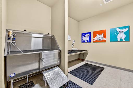 A room with a stainless steel table and three paintings on the wall.