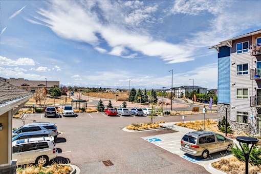 A parking lot with cars and a building in the background.