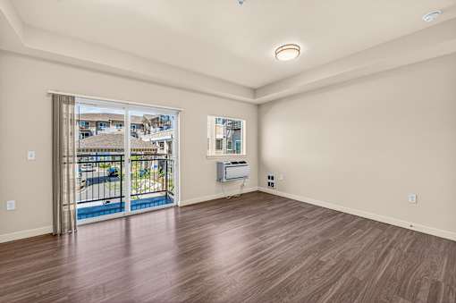 A room with a sliding glass door leading to a balcony.