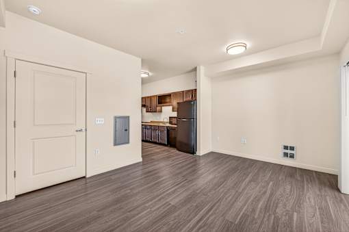 A room with a wooden floor and a door on the left side.