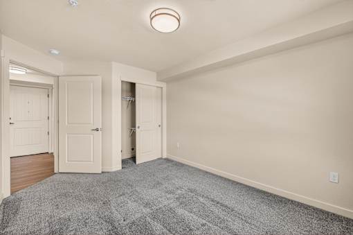 A room with a grey carpet and a white ceiling light.