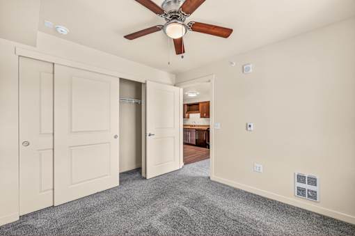 A room with a ceiling fan and a carpeted floor.