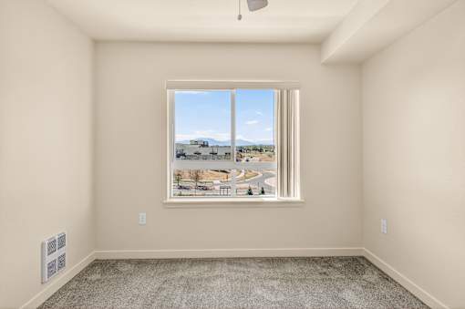 A room with a large window overlooking a cityscape.