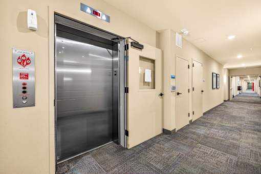 A long hallway with a closed elevator door on the left.