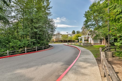 a curved road with a house and trees on the side of it