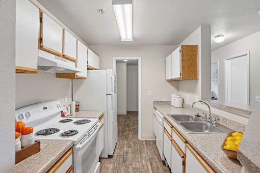 A kitchen with white appliances and wooden cabinets.