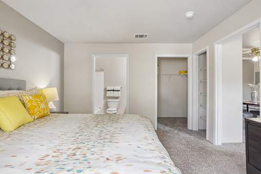 A bedroom with a bed, dresser, and mirror.
