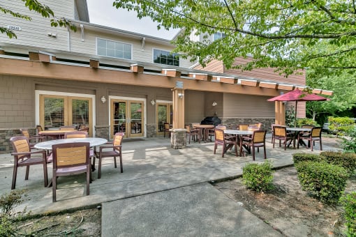a patio with tables and chairs outside of a building