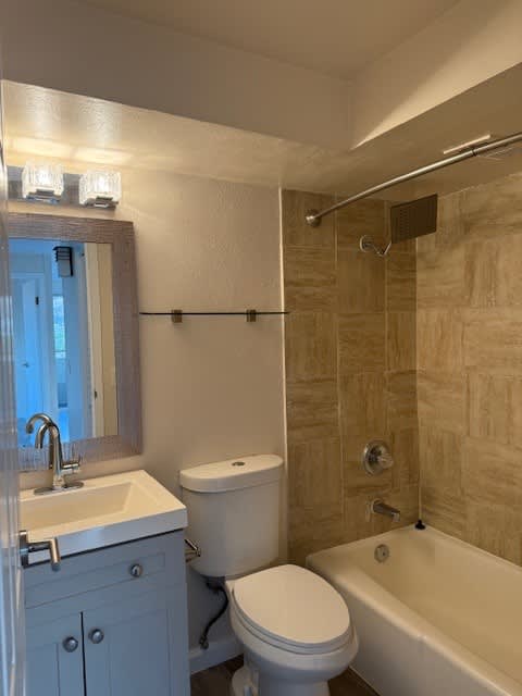 A bathroom with a toilet, sink, and bathtub.