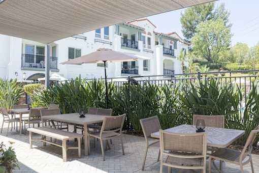 Horizons at Calabasas poolside patio with a table and chairs under a canopy.