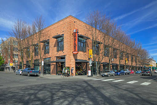 A red brick building with a yellow awning sits at a street corner.