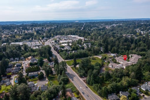 an aerial view of a neighborhood with a highway and trees