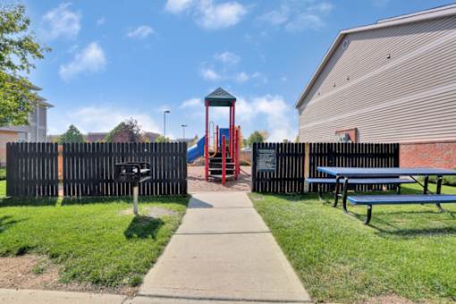 A playground with a slide and a playhouse.