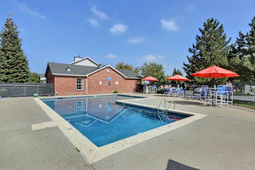 A red building with a pool in front of it.