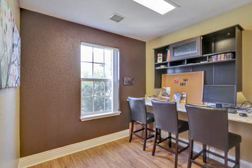 A brown room with a desk and chairs.