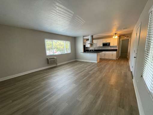 A room with wooden flooring and a window.