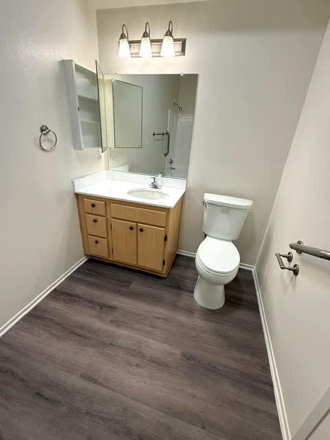Sorrento Villas bathroom with a toilet, sink, and mirror.