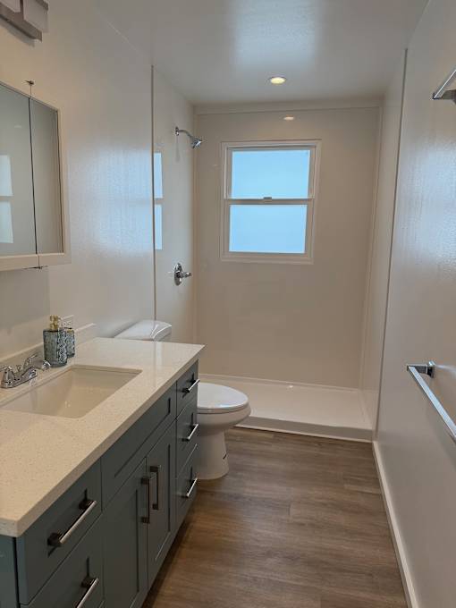 Pacific Oasis bathroom with a toilet, sink, and a window.