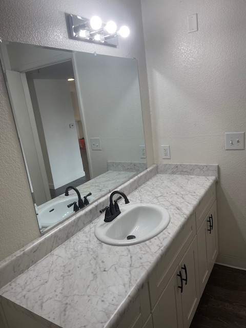 A white sink is mounted under a mirror in a bathroom.