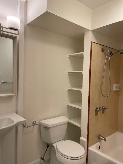 A white toilet sits next to a sink in a small bathroom.