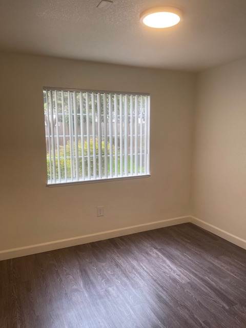 A window with blinds is open, allowing light to enter the room.