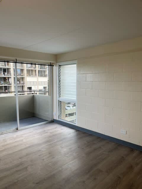 Napili Towers Bedroom with a wooden floor and a white wall with a window.