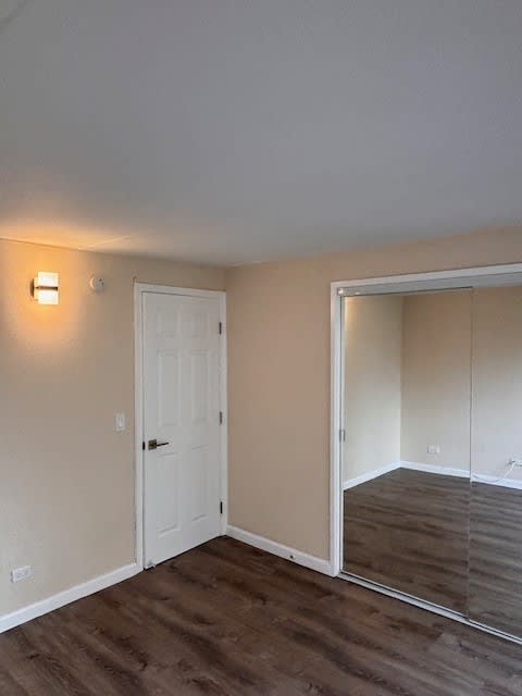 Napili Towers bedroom with a white door and a mirrored sliding closet.