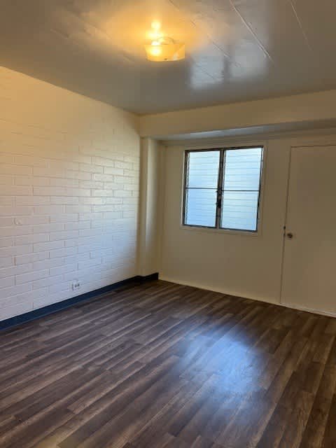 Pacific Oasis bedroom with a wooden floor and a window.