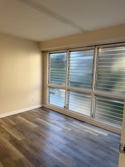 Napili Towers bedroom with windows and wooden flooring.