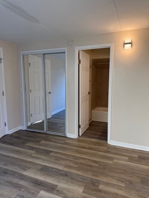 Napili Towers bedroom with a wooden floor and a white door.