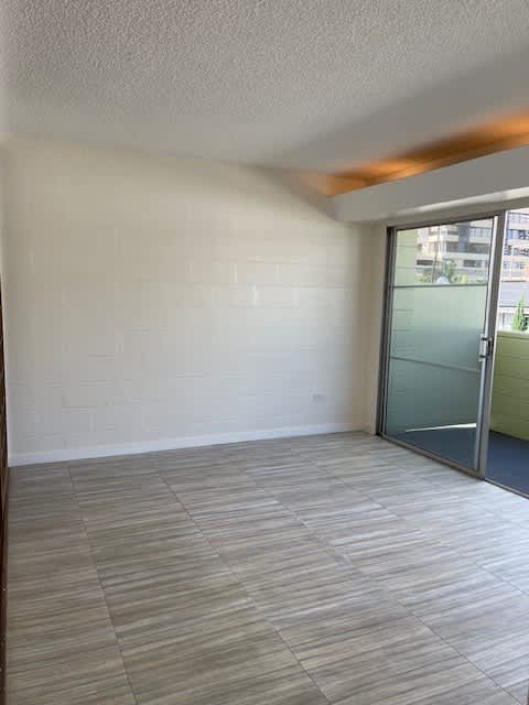 A room with a glass door and a tiled floor.