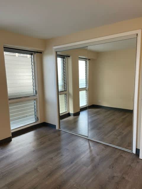 Napili Towers bedroom with a large mirror and wooden flooring.