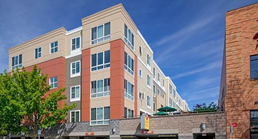 A multi-story building with a mix of beige and red facade.